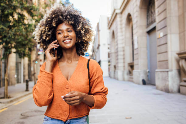 Portrait of a young African American woman on vacation exploring Barcelona and talking on mobile phone.